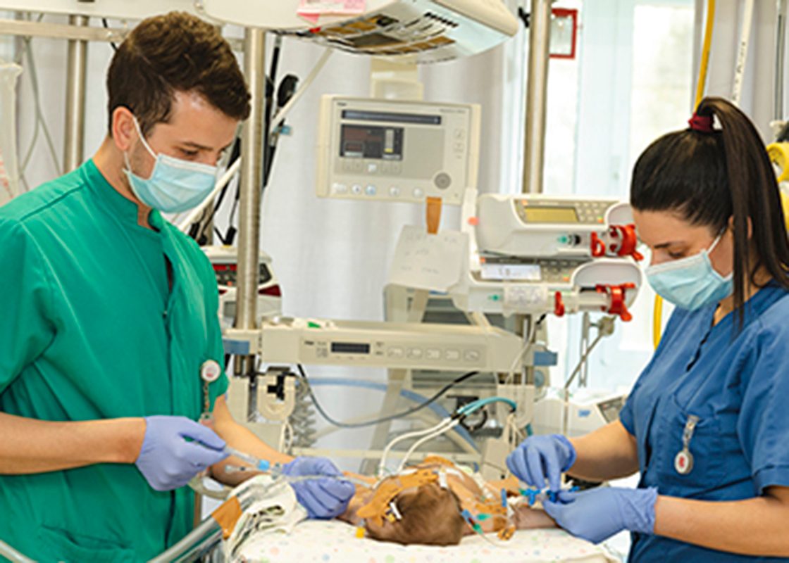 A doctor at Caritas Baby Hospital in Bethlehem examining a newborn while the mother looks on with relief